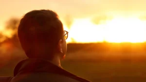 man-looking-at-bright-rising-sun.webp.webp