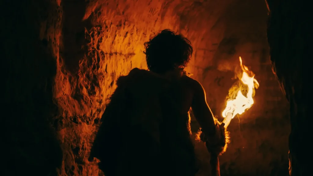 primeval-caveman-with-fire-torch-exploring-cave.webp.webp